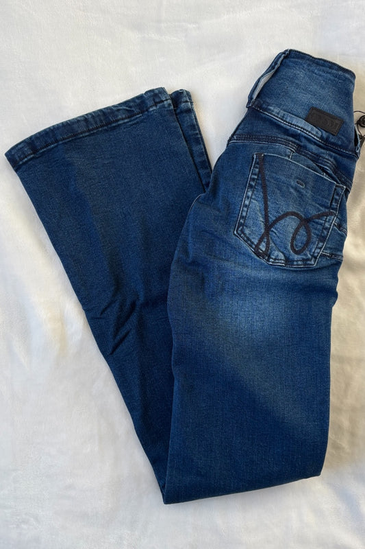 Pair of blue jeans on a textured white surface