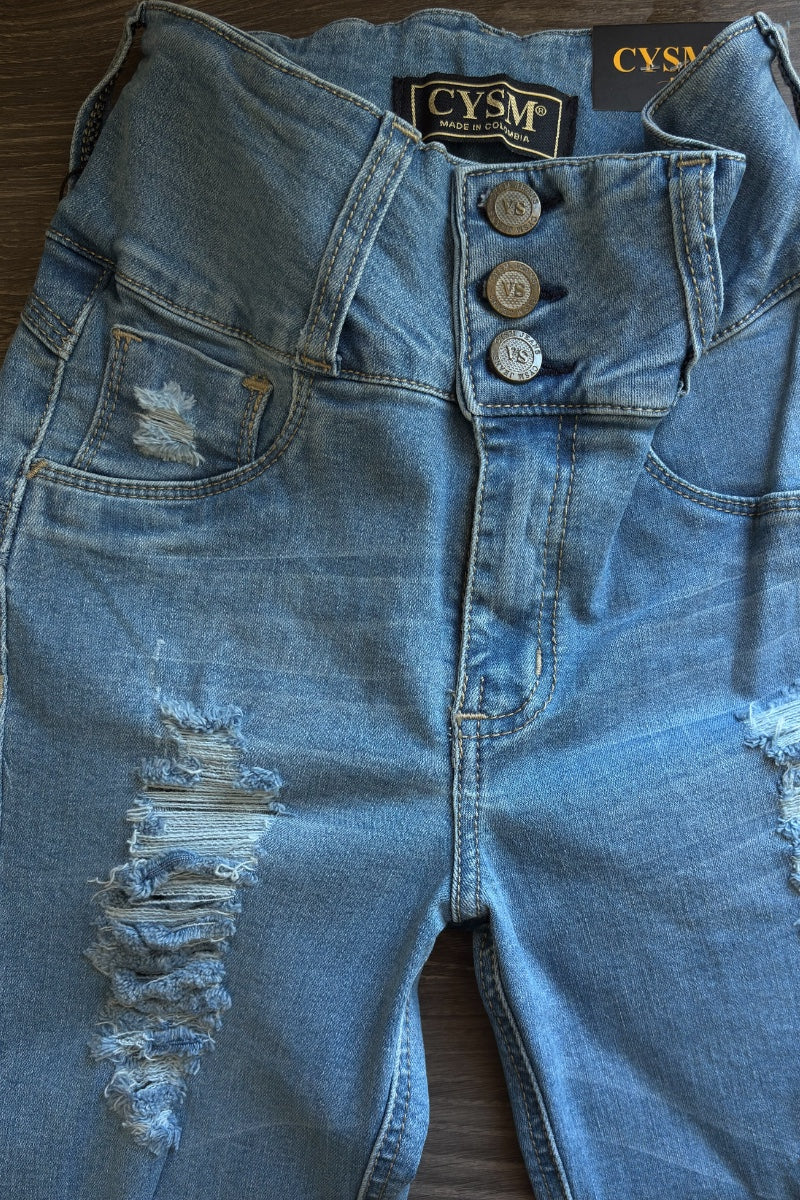 Distressed blue jeans with a visible brand label on a wooden surface
