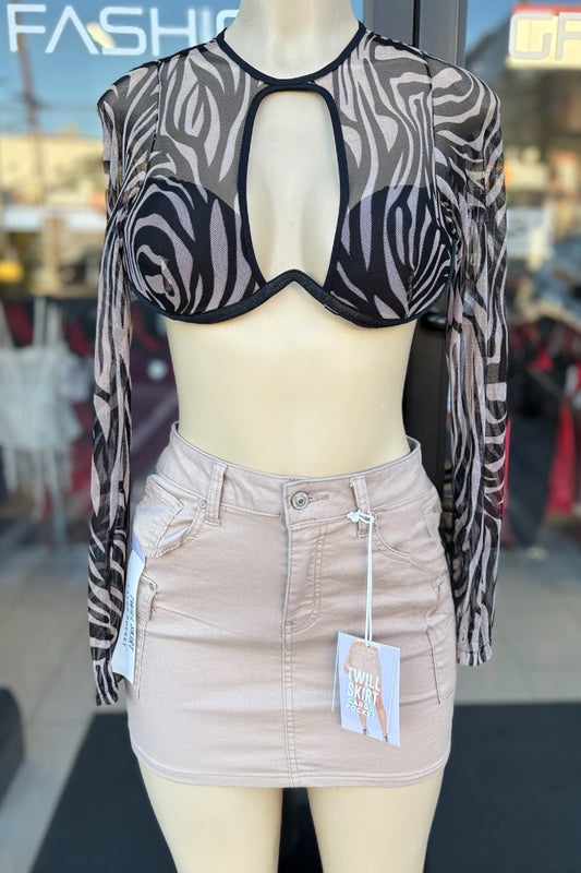 Mannequin wearing a zebra print top and beige skirt with tags in a store setting.