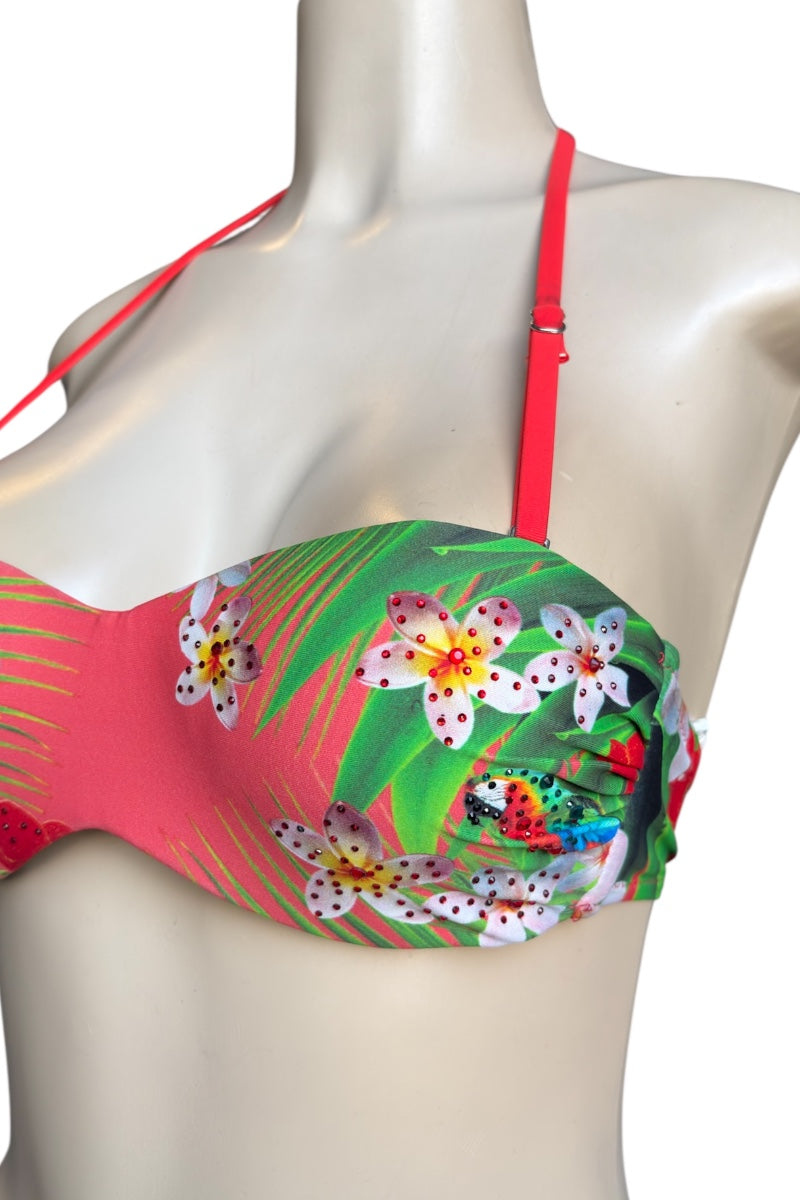 Colorful bikini top with floral and leaf patterns on a mannequin against a white background
