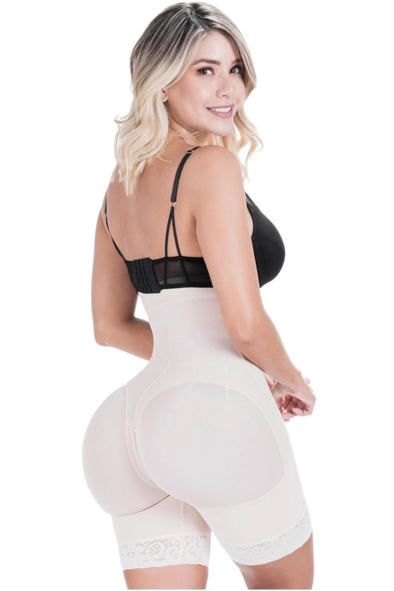 Woman wearing a black bra and beige shapewear on a white background