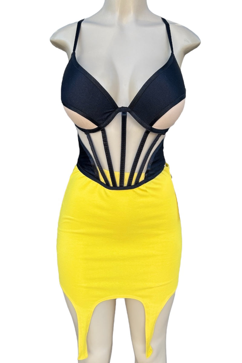 Mannequin wearing a black top and yellow skirt with a unique cut-out design.