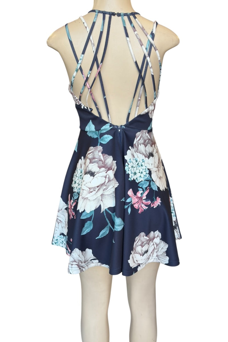 Floral dress with criss-cross straps on a mannequin against a white background
