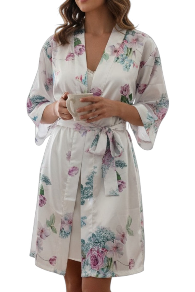 Woman wearing a white floral robe holding a cup on a white background