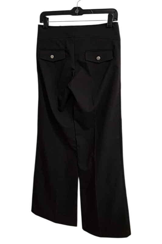 Black pants on a hanger against a white background