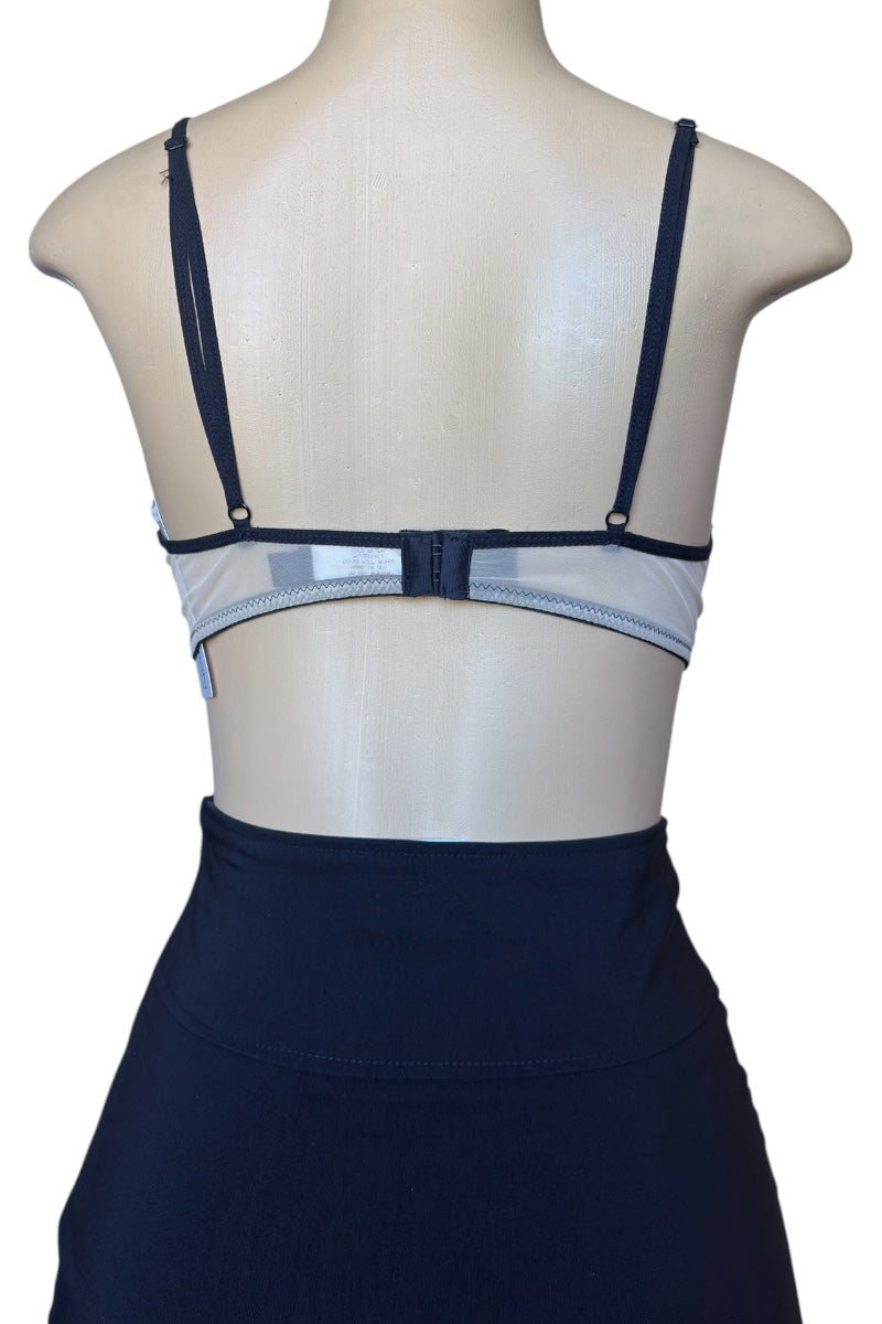 black bra with sheer mesh panels on a mannequin against a white background