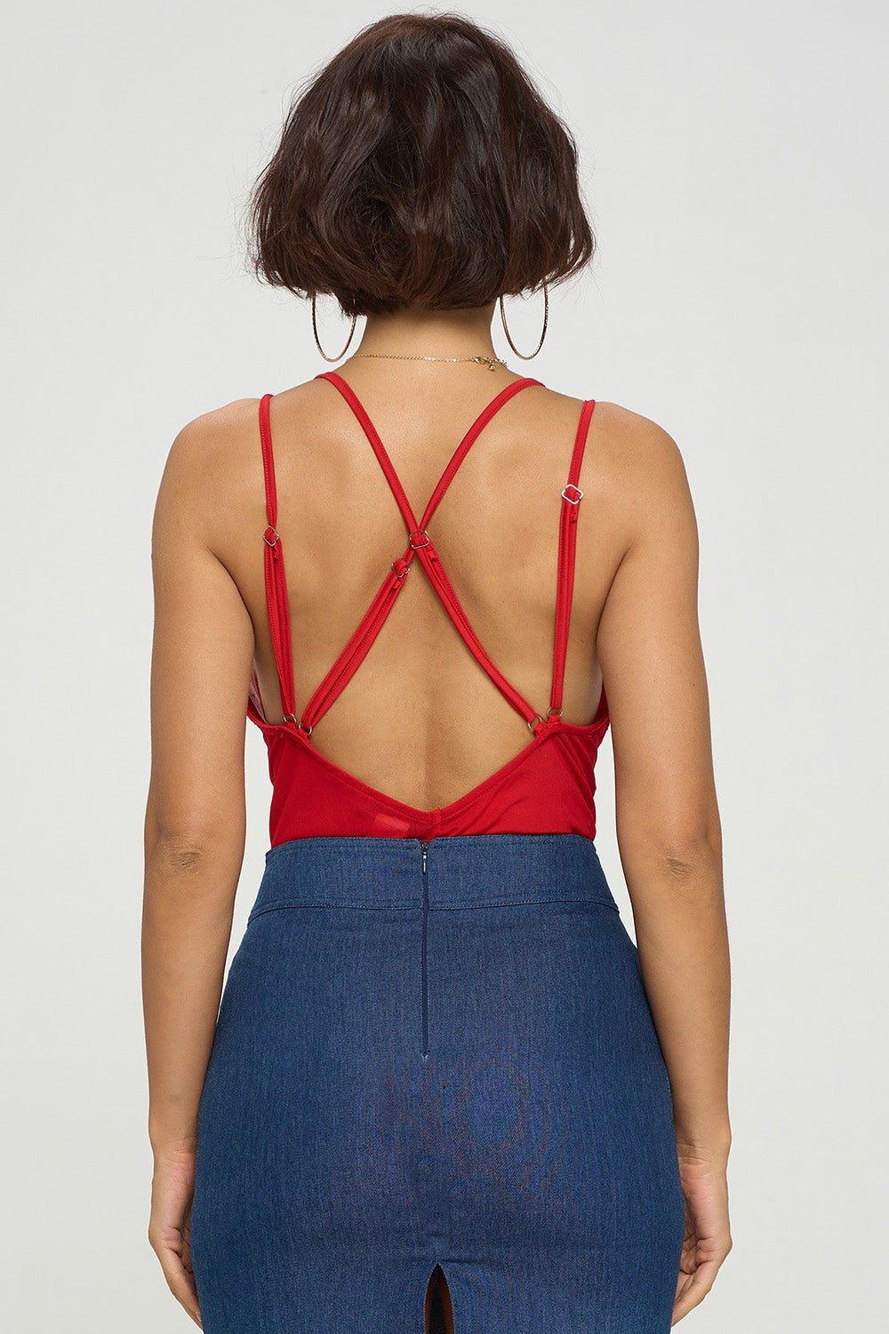 Person wearing a red strappy top and a blue skirt on a white background