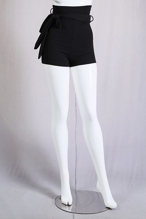 Mannequin wearing black shorts with a belt on a gray background