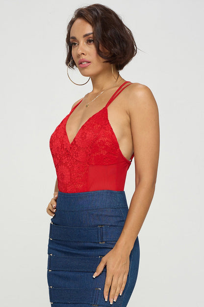 Woman wearing a red lace top and blue denim skirt on a white background