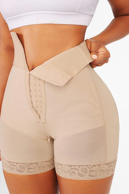 Beige shapewear shorts with lace trim worn by a person on a white background