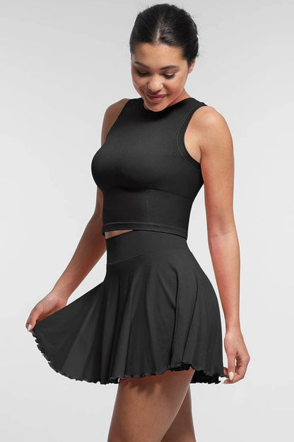 Woman wearing a black sleeveless top and skirt set on a white background