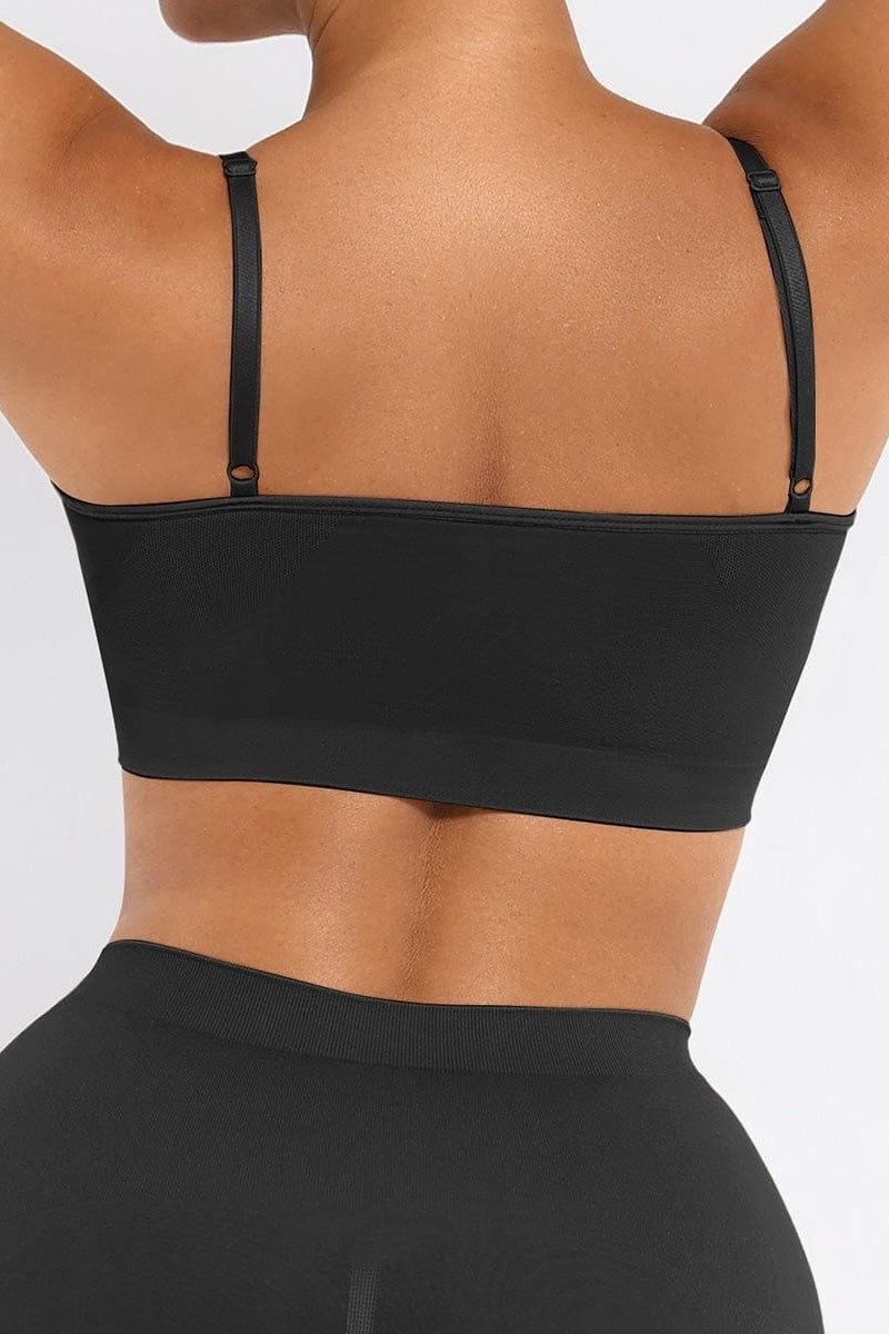 Black bralette worn by a person on a plain background