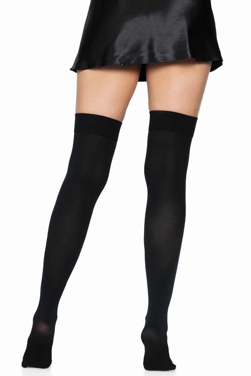 Black thigh-high socks worn with a black skirt on a white background