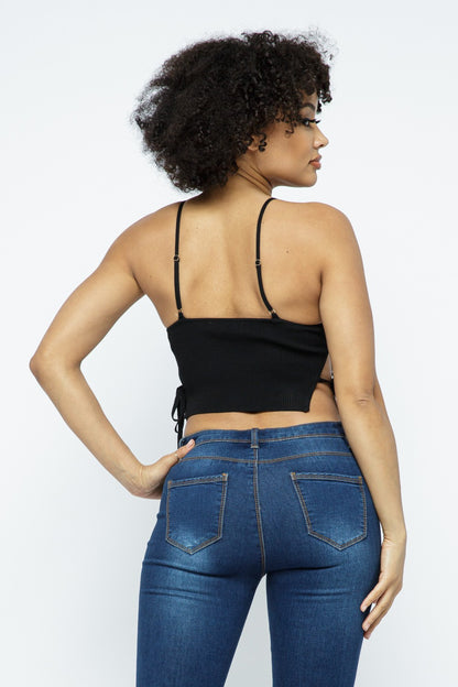Woman wearing a black top and blue jeans on a white background