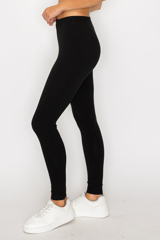 Person wearing black leggings and white sneakers on a white background