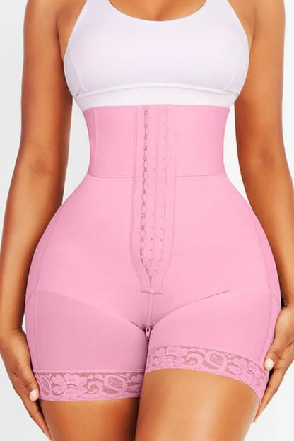Pink shapewear with lace details worn by a person on a white background
