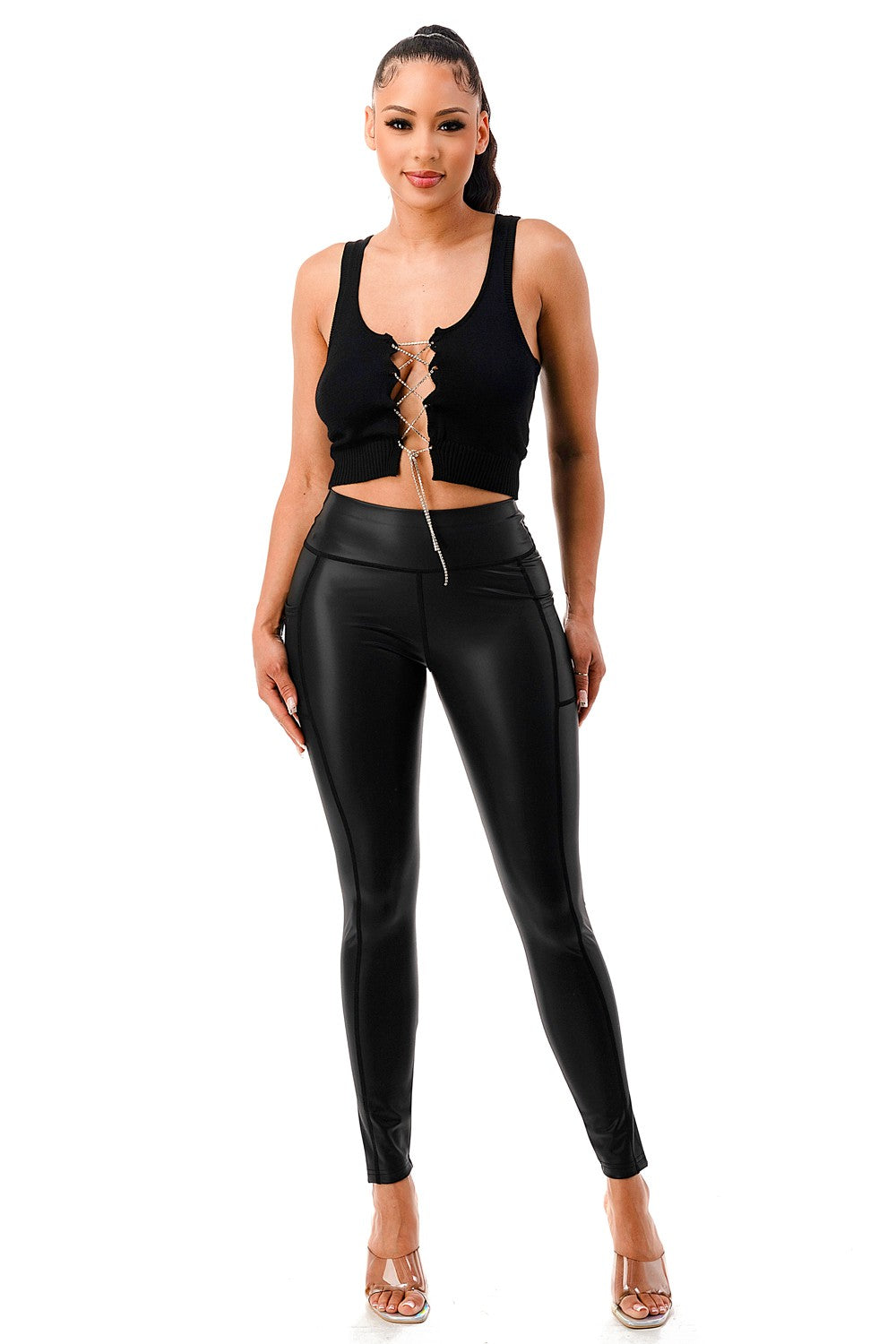 Woman wearing a black tank top and leggings on a white background