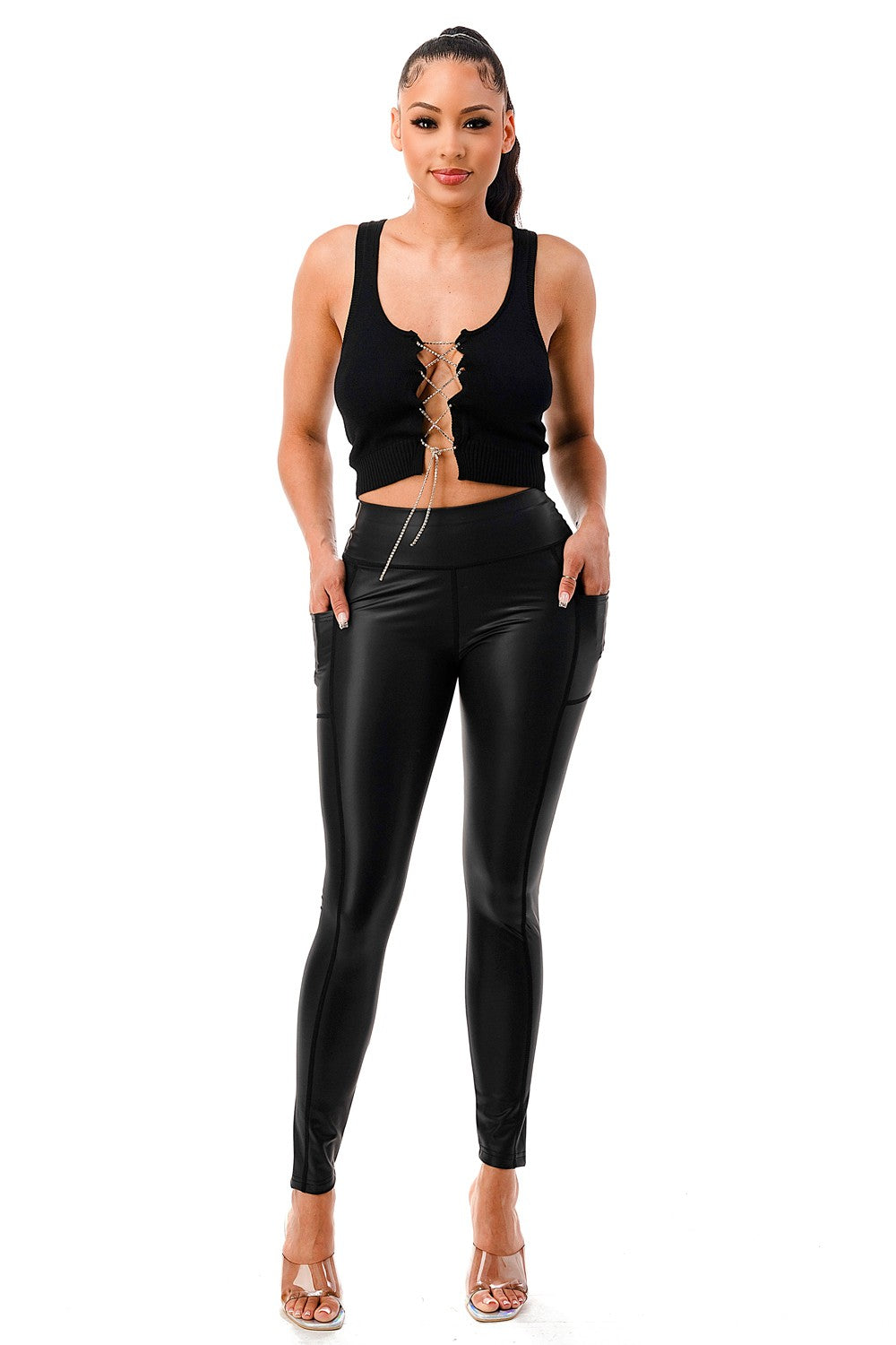 Woman wearing a black sleeveless top and black leather pants on a white background