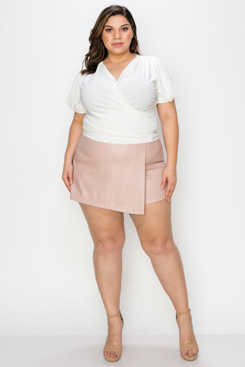 Woman wearing a white top and pink skirt on a white background