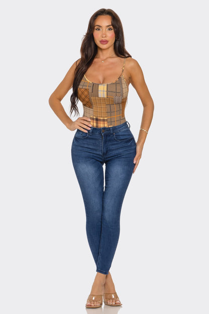 Woman wearing a plaid top and blue jeans on a white background