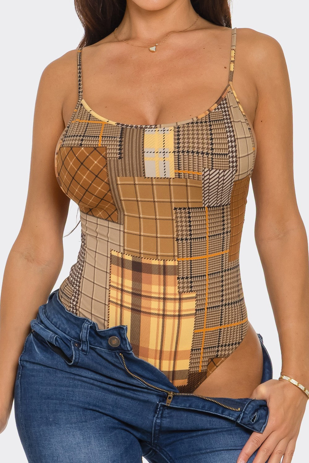 Woman wearing a plaid bodysuit with a white background