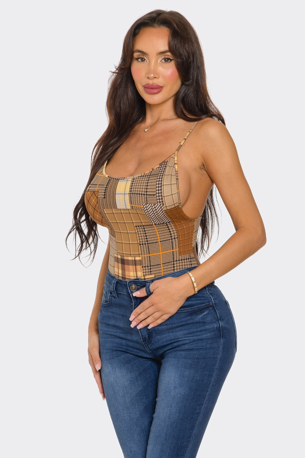 Woman wearing a plaid top and blue jeans on a white background