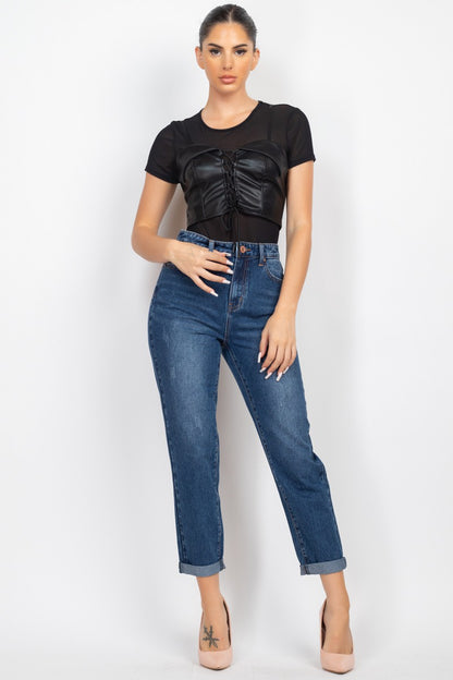 Woman wearing a black top and blue jeans on a white background
