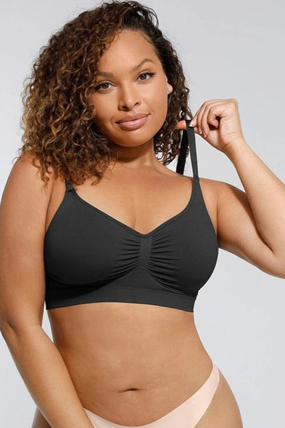 Woman wearing a black bralette top against a plain background