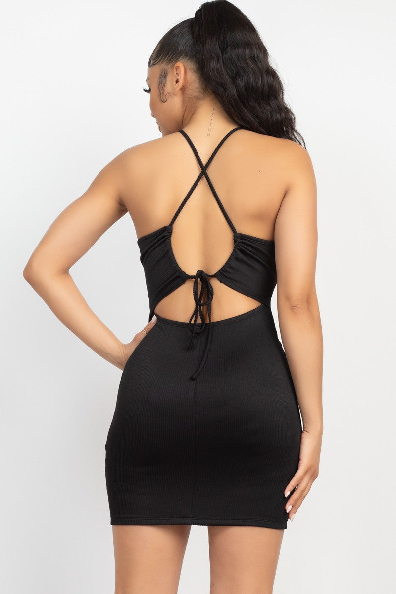 Black dress with open back worn by a model on a white background