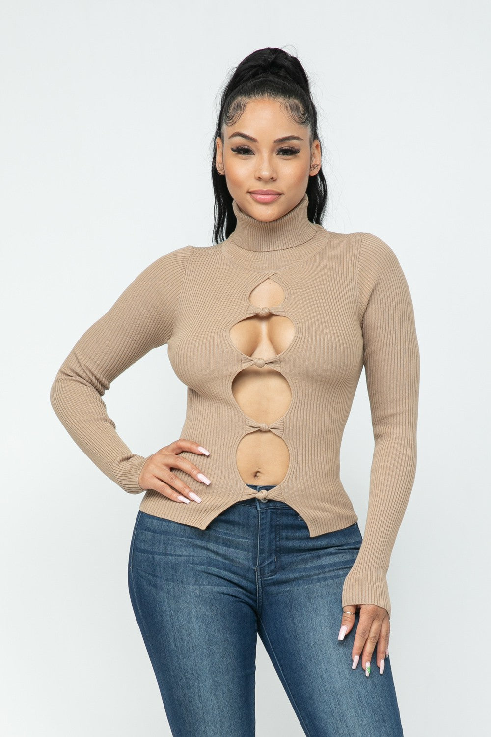 Woman wearing a milk coffee color long-sleeve top with cut-out design on a white background