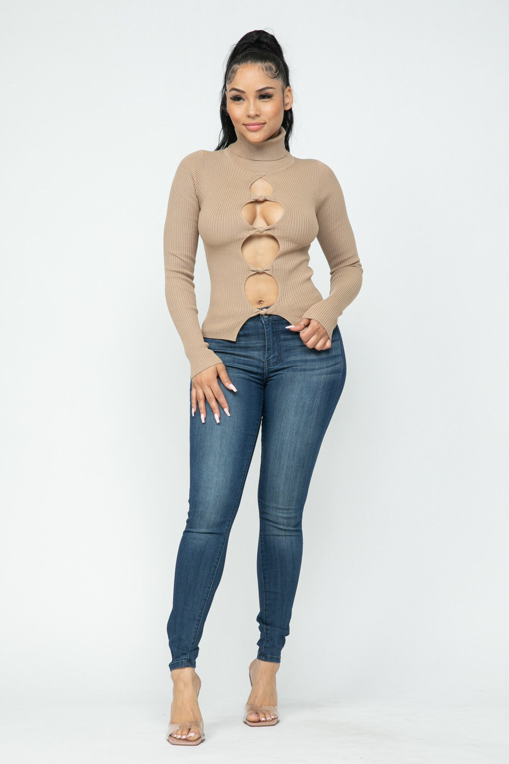 Woman wearing a  milk coffee color  turtleneck sweater and blue jeans on a white background