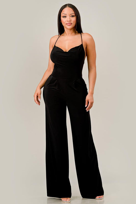 Woman wearing a black jumpsuit on a plain background