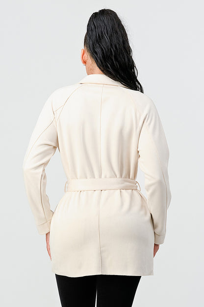 Woman wearing a cream-colored coat on a white background
