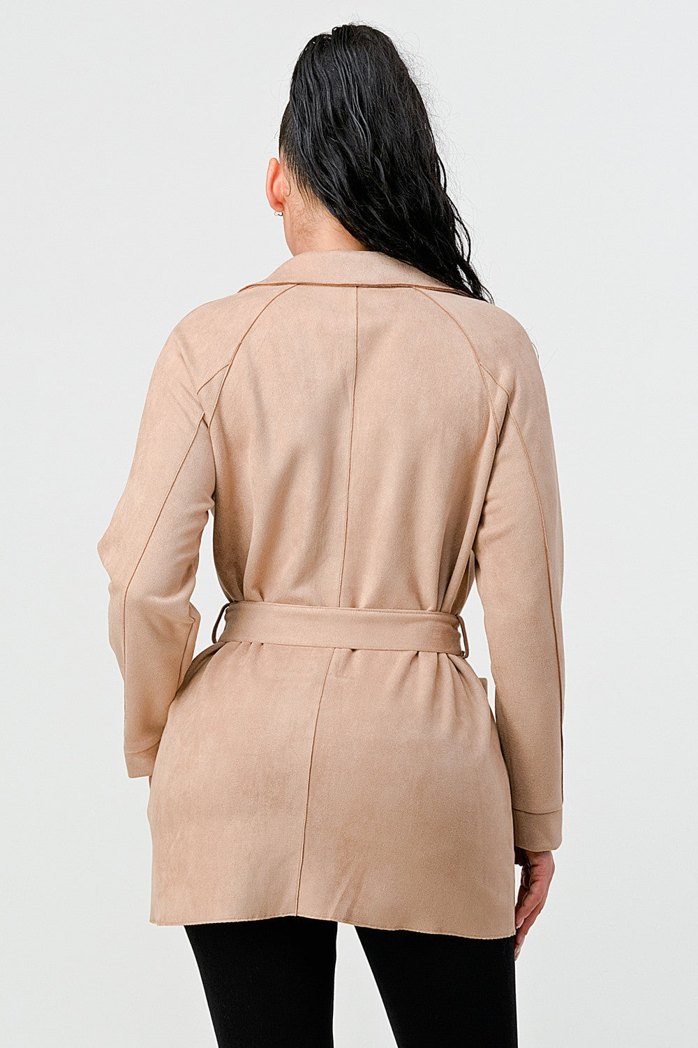 Woman wearing a beige trench coat on a white background