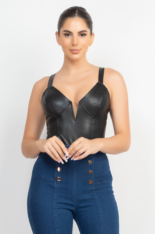 Woman wearing a black leather top and blue denim jumpsuit on a white background