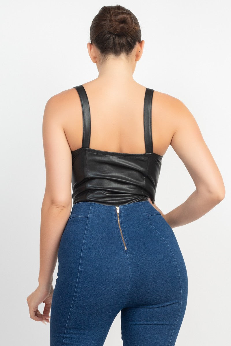 Person wearing a black leather top and blue jeans on a white background