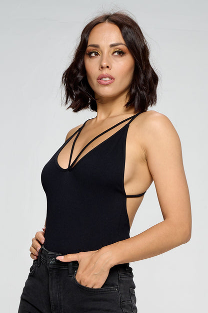 Woman wearing a black tank top against a plain background