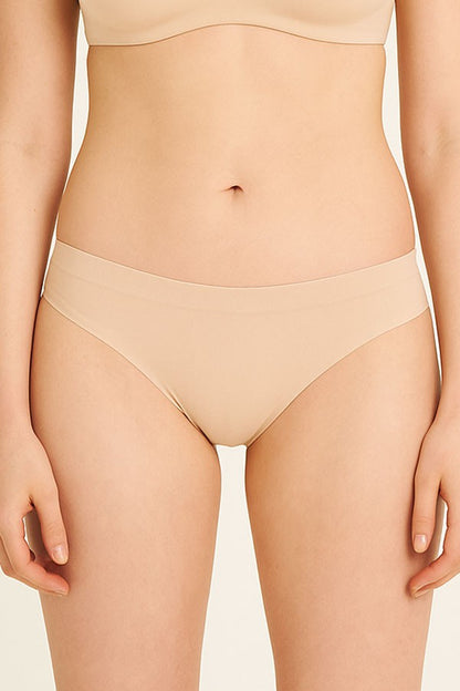 Beige underwear worn by a person on a plain background