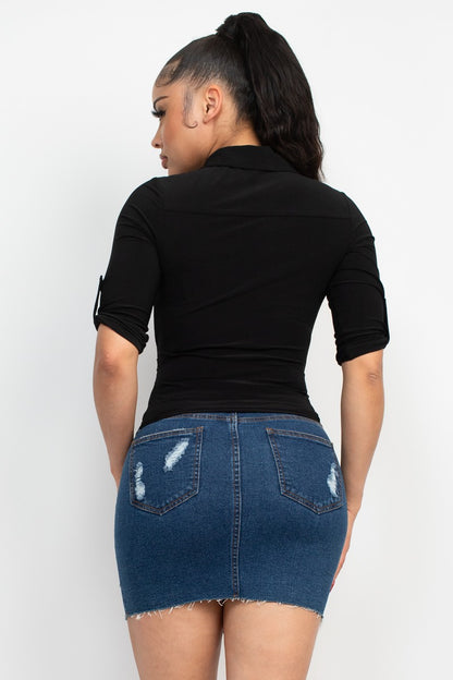 Person wearing a black top and denim skirt on a white background