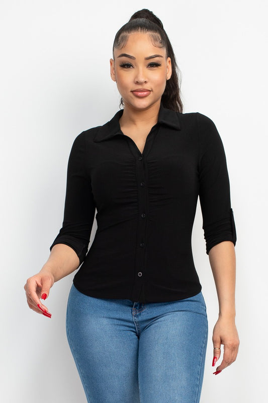 Woman wearing a black shirt and blue jeans against a white background