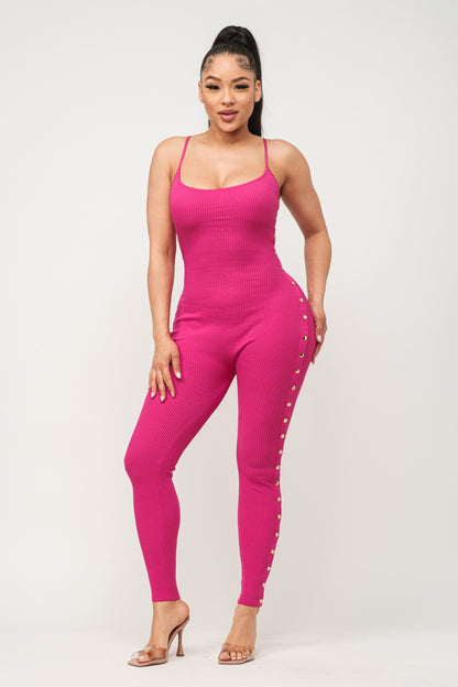 Woman wearing a fuchsia pink jumpsuit with button details on a white background