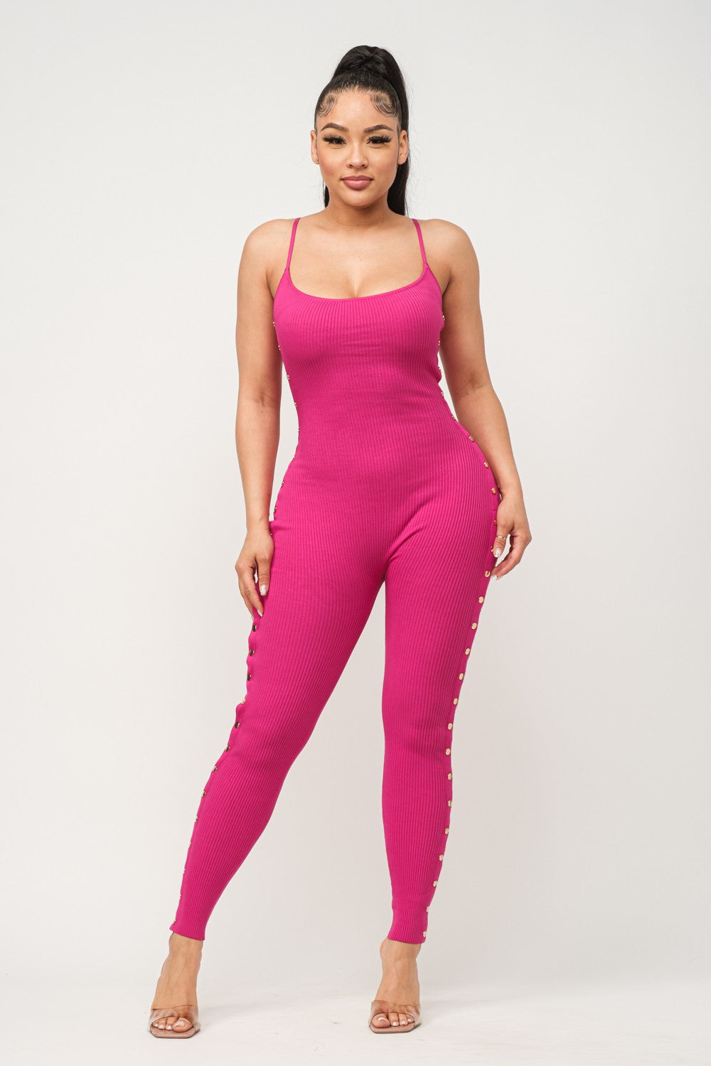 Woman wearing a fuchsia pink jumpsuit on a white background