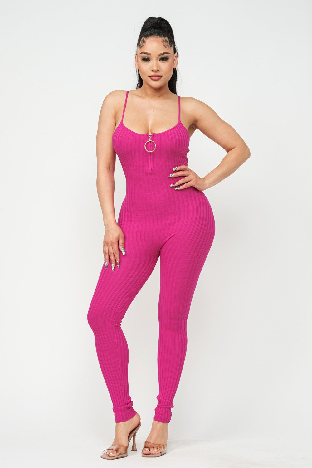 Woman wearing a fuchsia pink jumpsuit on a white background
