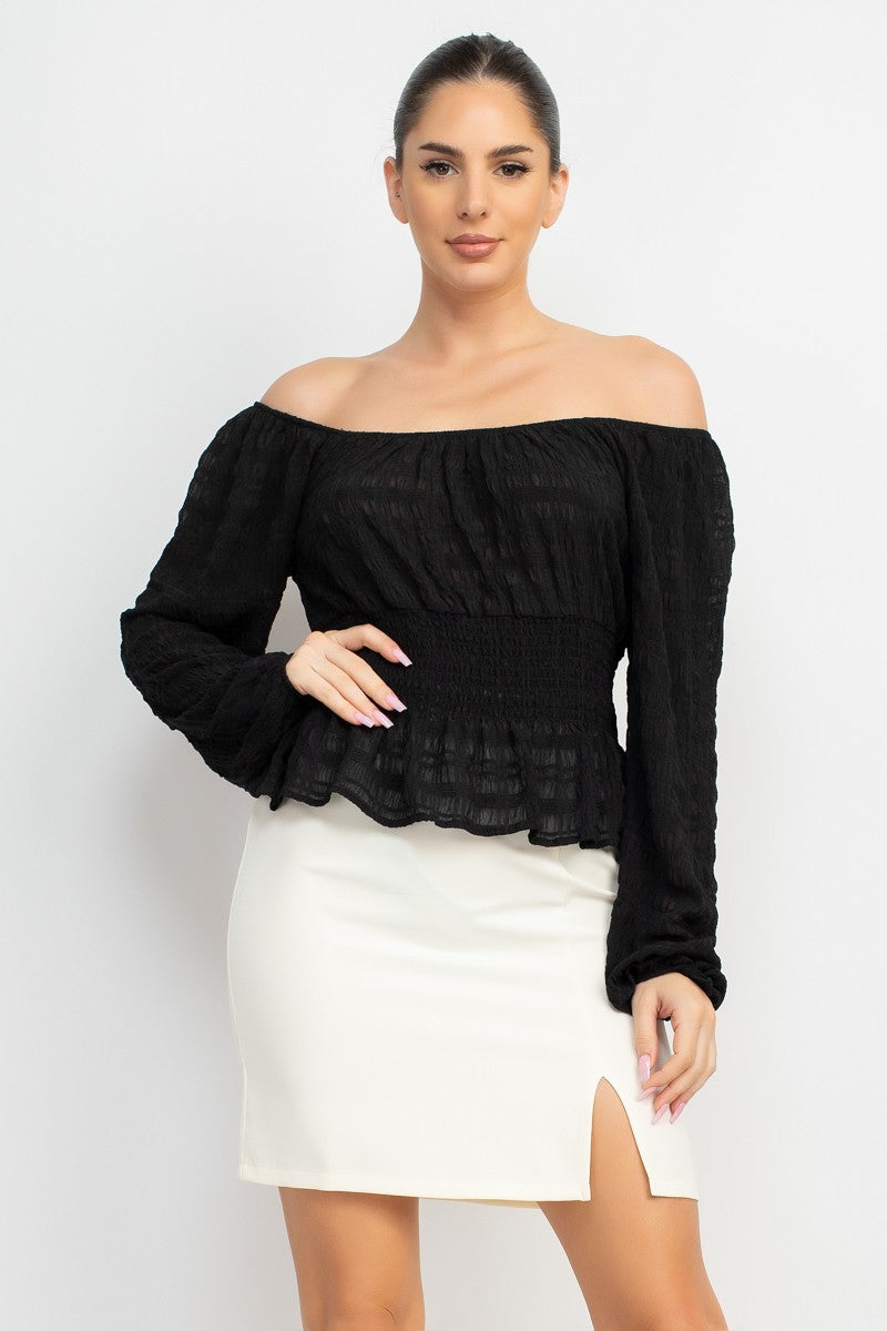 Woman wearing a black off-shoulder top and white skirt on a white background