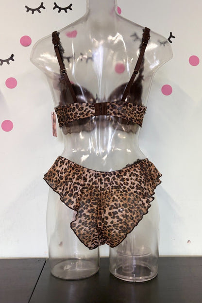A two-piece lingerie set with a brown and beige leopard print pattern, displayed on a clear plastic mannequin torso. The set includes a ruffled bandeau top and matching ruffled high-waisted briefs.