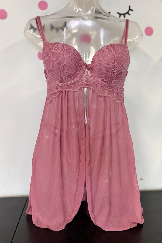 A pink sheer lingerie chemise with embroidered lace cups and thin shoulder straps, displayed on a clear mannequin torso against a white wall with pink polka dots.