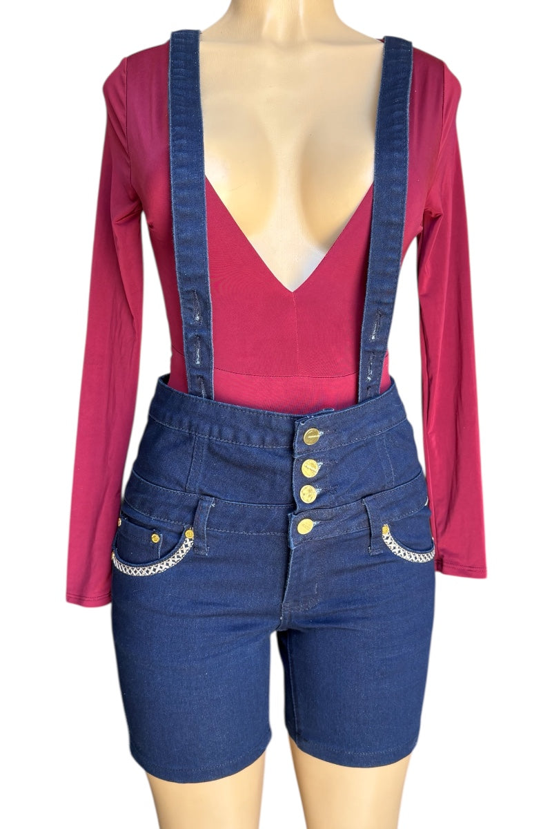 Mannequin wearing a red top and blue denim overalls with buttons on a white background