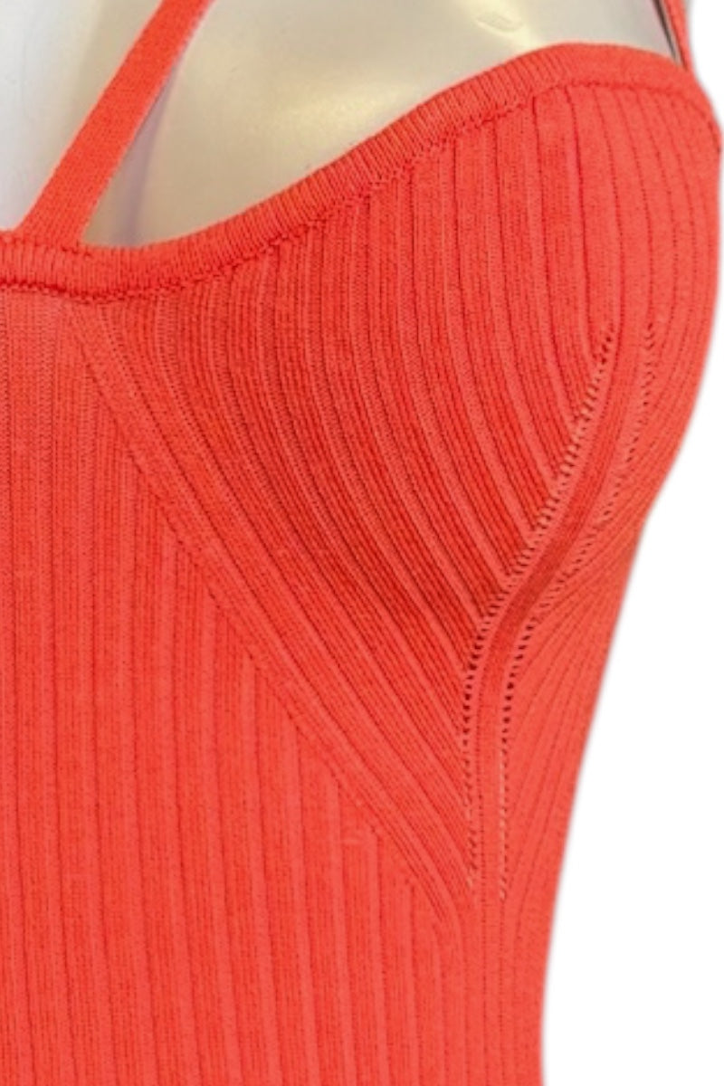 Close-up of a ribbed knit top in a bright coral-orange color, shown on a mannequin torso against a white background.