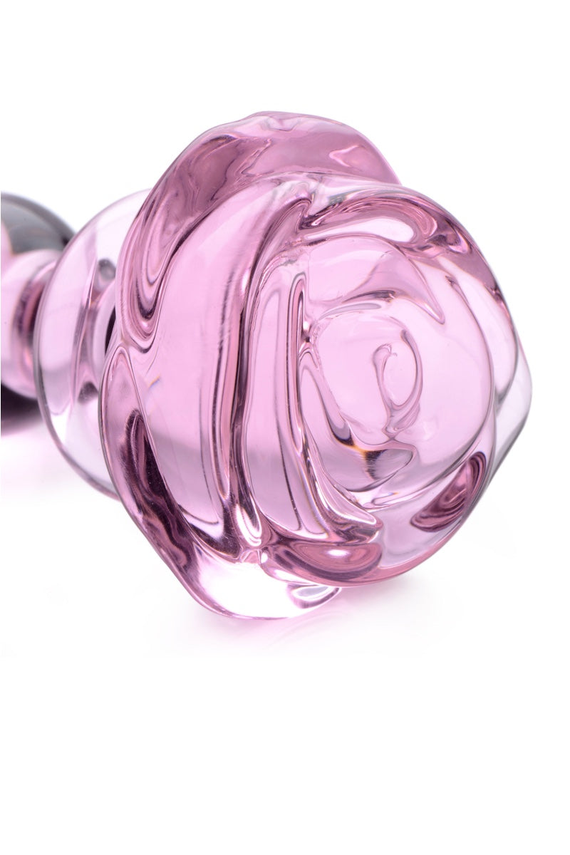 A translucent pink glass rose-shaped plug on a solid white background.