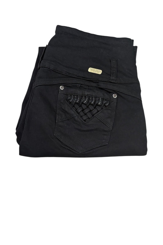 Black denim jeans folded to show the back pocket with a decorative woven patch and a small gold-tone brand plaque, on a white background.